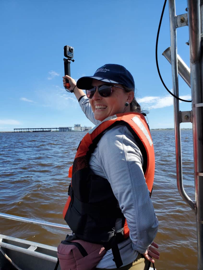 Beluga researcher C-Jae Breiter stands on a boat in the Churchill River Estuary
